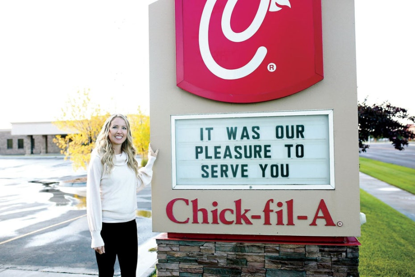  圖：一個女人站在 Chick Fil A 標(biāo)志旁邊的照片